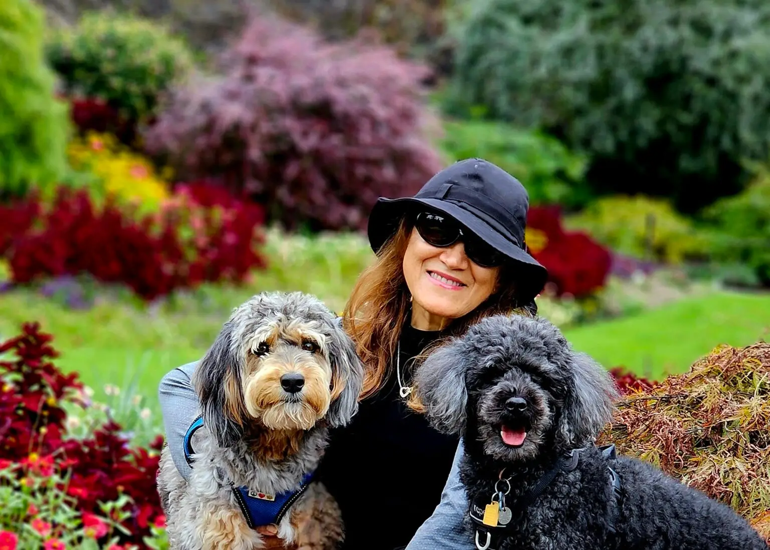 Yvonne sitting in a garden with two happy dogs